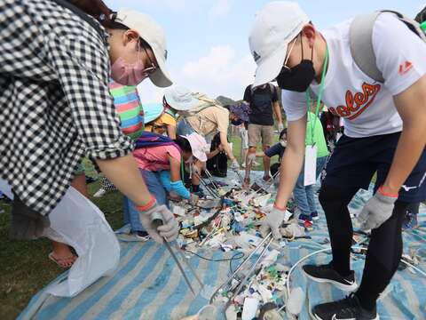 參與淨灘大小朋友一同合作進行海洋廢棄物分類回收