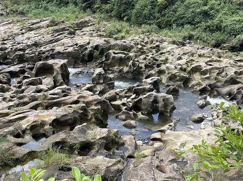 基隆河床岩石上有許多大大小小圓滑的坑洞就是世界級地理景觀「壺穴」