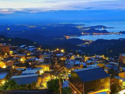 可在九份基山老街欣赏皎洁明月与山城夜景交织的独特景致。