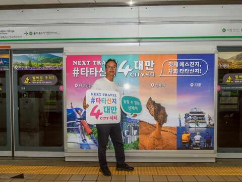 新北市觀旅局楊宗珉局長於首爾旅展期間，在市中心乙支路入口捷運站的4市旅遊形象廣告前活潑介紹新北市觀光。