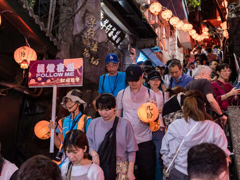 活动现场涌入民众手持九份小灯笼参与「百人提灯夜游」，沉浸在灯笼海交织的光影中，展现九份夜色的温柔魅力。