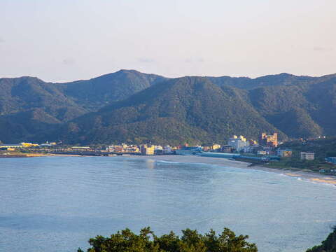 翡翠湾位於新北市万里区，为北海岸知名的海湾景点。湾区弧形绵长，沿岸聚落与山景相映，构成海天一色的经典景观。