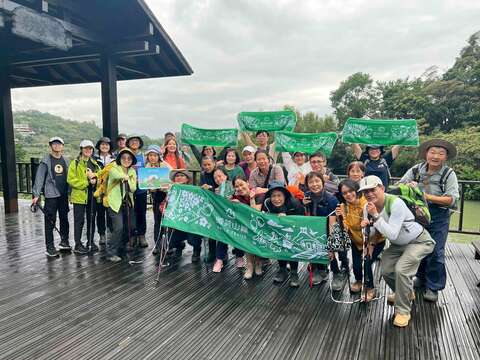 参与者手持活动旗帜与标志，纪录此次健行成果。