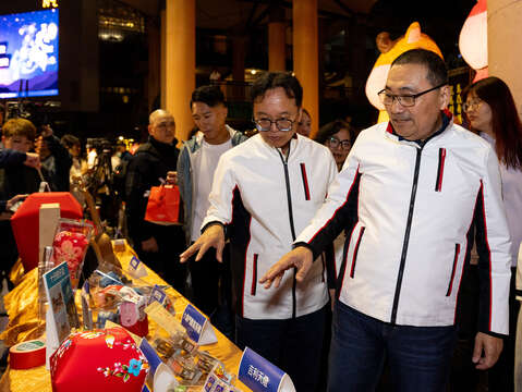 侯友宜市長、代言人陳彥博與觀旅局長於平溪商圈攤位上參觀在地特色文創商品。