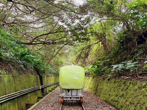可愛的河豚車穿梭在綠意盎然的鐵道廊帶中，展現出將廢棄軌道成功活化並帶動區域共好的核心價值。
