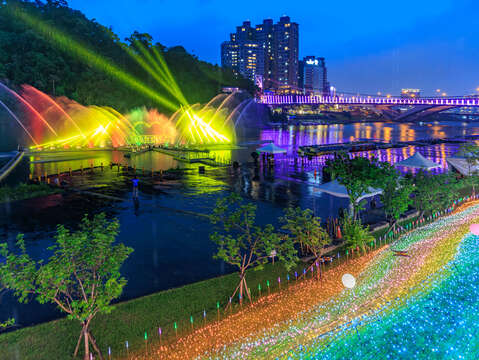 夜幕降臨，碧潭水域化身流光舞台，七彩水柱隨音樂律動綻放，與吊橋燈飾及岸邊光廊交織成一幅夢幻夜景，揭開2026碧潭水舞季序幕。(由攝影師Justin Cheng拍攝)