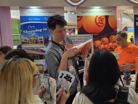 菲律賓民眾至新北市政府觀光旅遊局展區民眾熱絡詢問旅遊資訊及集章活動領取贈品