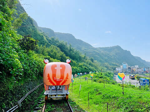 旅客搭乘深澳鐵道自行車特製的螃蟹造型車依山傍海前行，沿途不僅能飽覽新北北海岸的翠綠山巒，更能將開闊的海景盡收眼底。