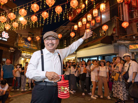 侯友宜市长提着造型小提灯，在昇平戏院下的璀璨红灯笼海邀请大家一起来九份游玩。