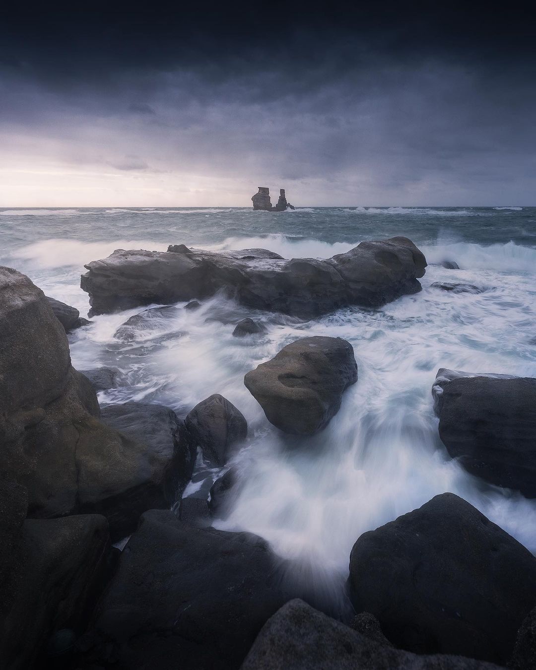 湍急的海水擊在岩石上，形成朵朵美麗的浪花 