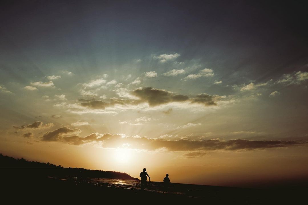 海面上的夕陽餘暉，熠熠金光照著大地，包圍著我們 