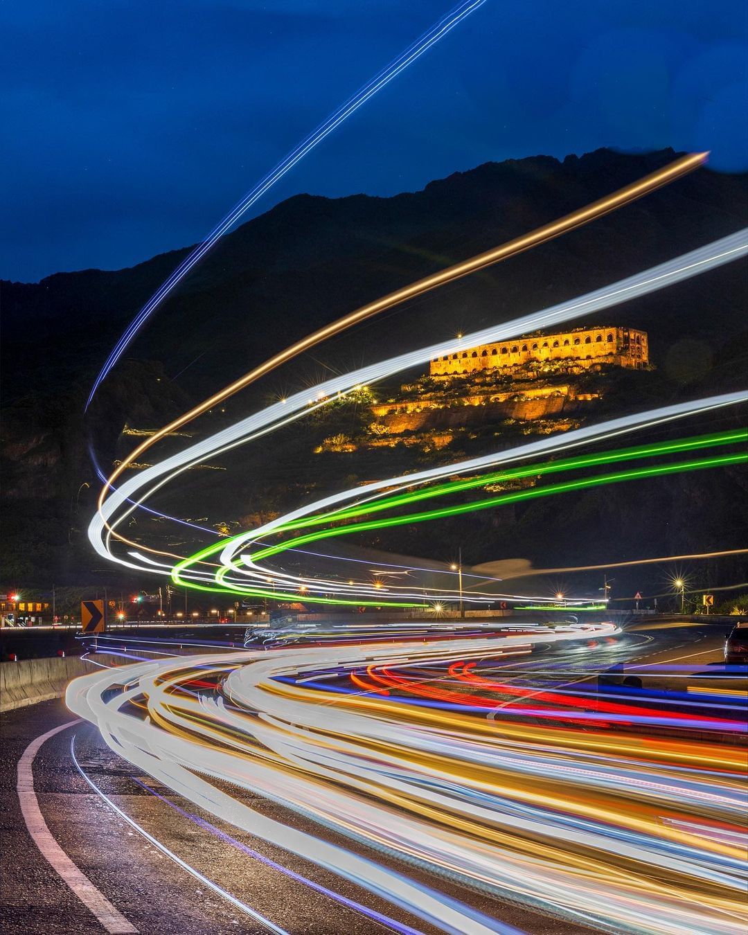 十三層遺址靜靜地籠罩在溫暖燈光中，濱海公路上耀眼的車軌就像流動的時光，一動一靜的光影，形成美麗的夜景！