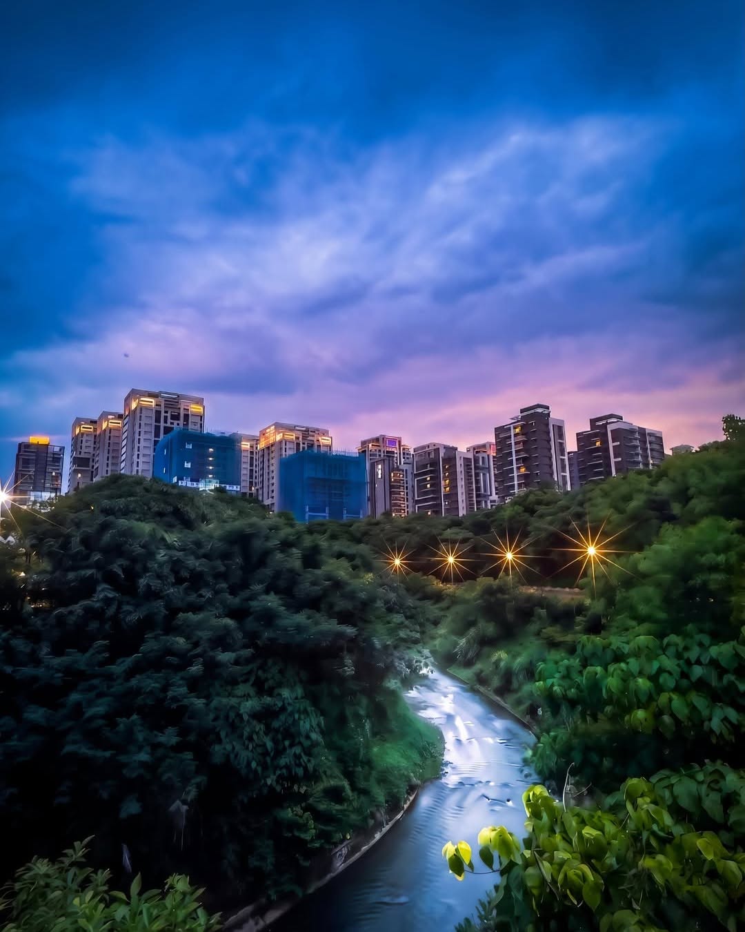 黃昏時分的公司田溪步道，天空暈染上夢幻的暮色，遠處亮起的路燈宛如夜空初現的繁星。找個時間來這裡走走吧，把生活的步調調慢，迷失在淡水最浪漫的魔幻時刻裡 