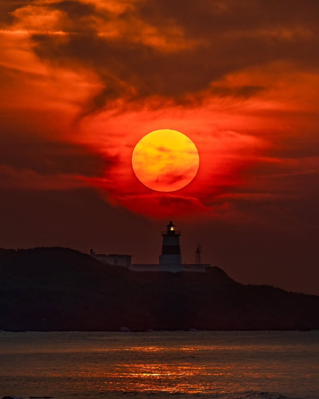 夕陽餘暉，染紅了整片天際，也將守望在海角的富貴角燈塔，擁入懷中