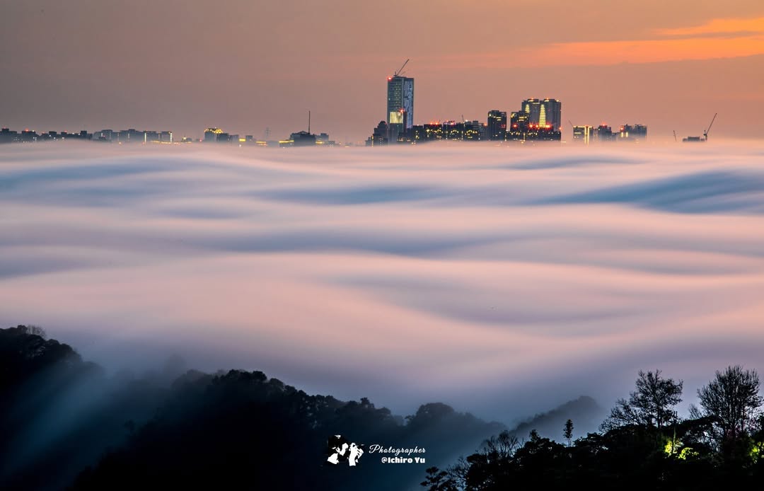 雲海翻騰，城市如孤島般在光影中閃爍