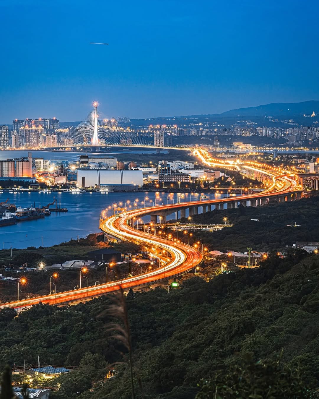 蜿蜒在城市與夜空之間的金色巨龍，點亮了淡水河口的絕美夜色