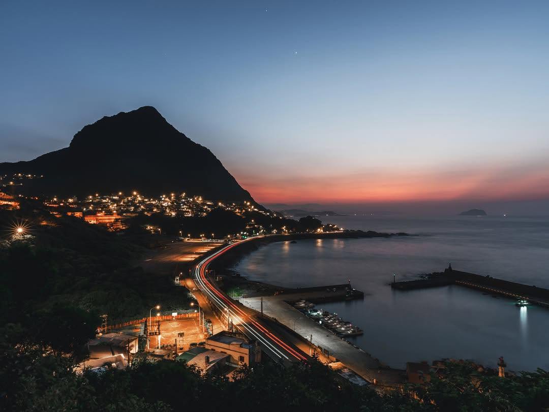 蜿蜒公路上的車燈流轉，遠處的基隆嶼在暮色中靜靜佇立山城的燈火伴著海浪聲依序亮起，這份獨特的寧靜，總能讓人忘卻所有的喧囂